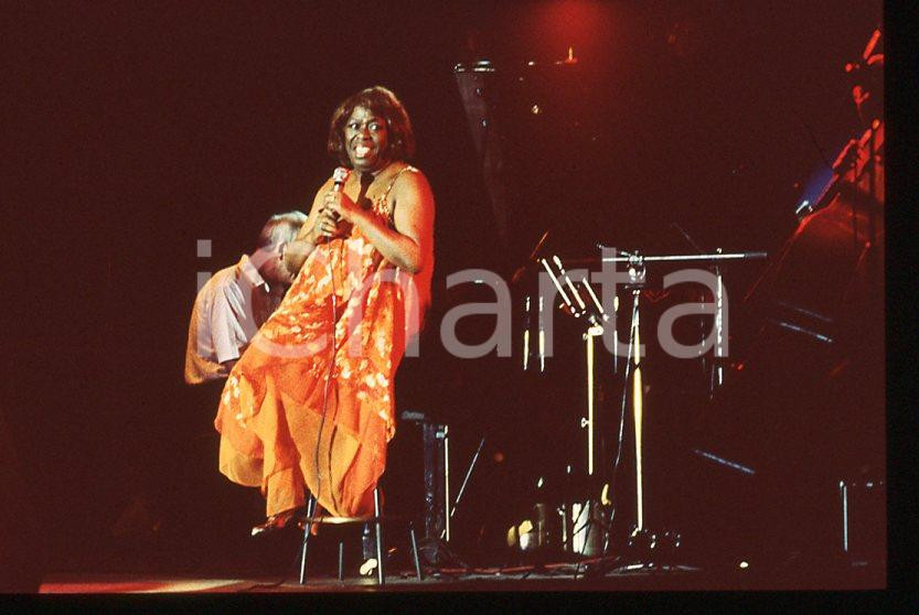 Sarah VAUGHAN jazz singer - Casinò di CAMPIONE 1985 ca *35 mm vintage slide (2) Diapositiva d'epoca, in formato 35 mm.Per i diritti rivolgersi a ICharta.E' severamente vietata la riproduzione. Tutti i diritti sono riservati.ICharta mette in vendita, sul negozio eBay e in esclusiva sul sito "icharta" il proprio archivio composto da numerose diapositive e negativi fotografici d'epoca, tutti originali e autentici, che attraversano la storia del costume tra la fine degli anni Sessanta e Novanta.Si tratta di uno sguardo inedito sull'attualità, la politica, la vita quotidiana, il gossip e la cultura, che fotografa il cambiamento della nazione in quest'ultimo scorcio del XX secolo. Un'occasione unica per il mercato del collezionismo, che vede finalmente disponibile un archivio eccezionale per vastità, tematiche e condizioni, in un settore (il negativo fotografico e la diapositiva) di assoluta novità e dalle interessanti prospettive di investimento.  GOOD/buono   originale e autentica 1