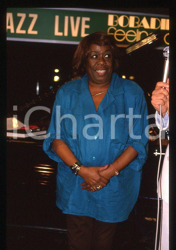 Sarah VAUGHAN jazz singer - BOBADILLA DALMINE 1985 ca *35 mm vintage slide (2) Diapositiva d'epoca, in formato 35 mm.Si tratta del concerto di Sarah Vaughan al Bobadilla Feeling Club di Dalmine (BG).Per i diritti rivolgersi a ICharta.E' severamente vietata la riproduzione. Tutti i diritti sono riservati.ICharta mette in vendita, sul negozio eBay e in esclusiva sul sito "icharta" il proprio archivio composto da numerose diapositive e negativi fotografici d'epoca, tutti originali e autentici, che attraversano la storia del costume tra la fine degli anni Sessanta e Novanta.Si tratta di uno sguardo inedito sull'attualità, la politica, la vita quotidiana, il gossip e la cultura, che fotografa il cambiamento della nazione in quest'ultimo scorcio del XX secolo. Un'occasione unica per il mercato del collezionismo, che vede finalmente disponibile un archivio eccezionale per vastità, tematiche e condizioni, in un settore (il negativo fotografico e la diapositiva) di assoluta novità e dalle interessanti prospettive di investimento.  GOOD/buono   originale e autentica 1