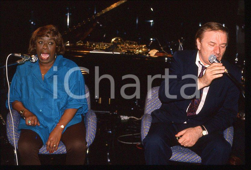 Sarah VAUGHAN Pier Quinto CARIAGGI - DALMINE 1985 ca *35 mm vintage slide (2) Diapositiva d'epoca, in formato 35 mm.Si tratta della serata di Sarah Vaughan al Bobadilla Feeling Club di Dalmine (BG).Per i diritti rivolgersi a ICharta.E' severamente vietata la riproduzione. Tutti i diritti sono riservati.ICharta mette in vendita, sul negozio eBay e in esclusiva sul sito "icharta" il proprio archivio composto da numerose diapositive e negativi fotografici d'epoca, tutti originali e autentici, che attraversano la storia del costume tra la fine degli anni Sessanta e Novanta.Si tratta di uno sguardo inedito sull'attualità, la politica, la vita quotidiana, il gossip e la cultura, che fotografa il cambiamento della nazione in quest'ultimo scorcio del XX secolo. Un'occasione unica per il mercato del collezionismo, che vede finalmente disponibile un archivio eccezionale per vastità, tematiche e condizioni, in un settore (il negativo fotografico e la diapositiva) di assoluta novità e dalle interessanti prospettive di investimento.  GOOD/buono   originale e autentica 1