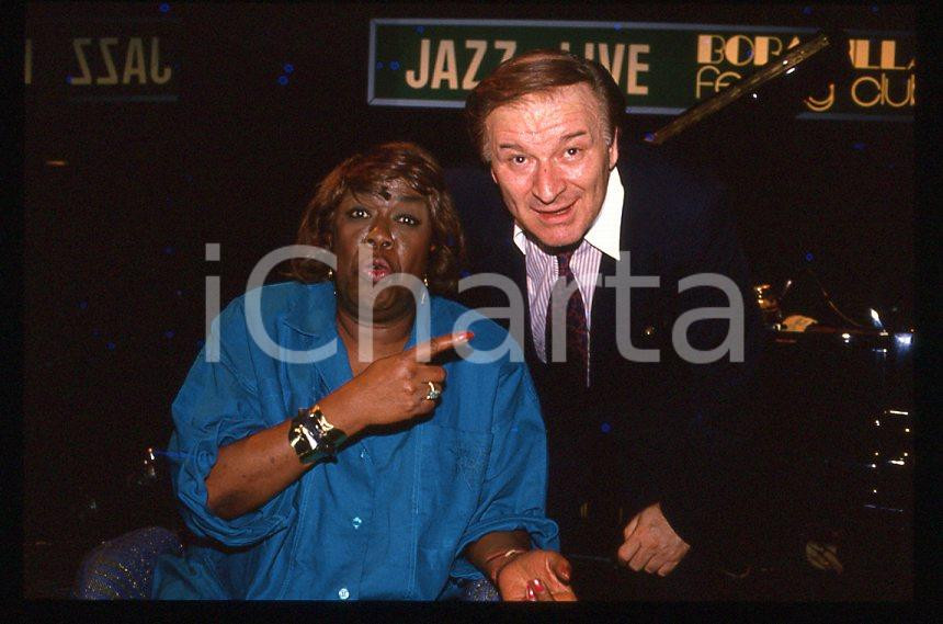 Sarah VAUGHAN Pier Quinto CARIAGGI - DALMINE 1985 ca *35 mm vintage slide (4) Diapositiva d'epoca, in formato 35 mm.Si tratta della serata di Sarah Vaughan al Bobadilla Feeling Club di Dalmine (BG).Per i diritti rivolgersi a ICharta.E' severamente vietata la riproduzione. Tutti i diritti sono riservati.ICharta mette in vendita, sul negozio eBay e in esclusiva sul sito "icharta" il proprio archivio composto da numerose diapositive e negativi fotografici d'epoca, tutti originali e autentici, che attraversano la storia del costume tra la fine degli anni Sessanta e Novanta.Si tratta di uno sguardo inedito sull'attualità, la politica, la vita quotidiana, il gossip e la cultura, che fotografa il cambiamento della nazione in quest'ultimo scorcio del XX secolo. Un'occasione unica per il mercato del collezionismo, che vede finalmente disponibile un archivio eccezionale per vastità, tematiche e condizioni, in un settore (il negativo fotografico e la diapositiva) di assoluta novità e dalle interessanti prospettive di investimento.  GOOD/buono   originale e autentica 1