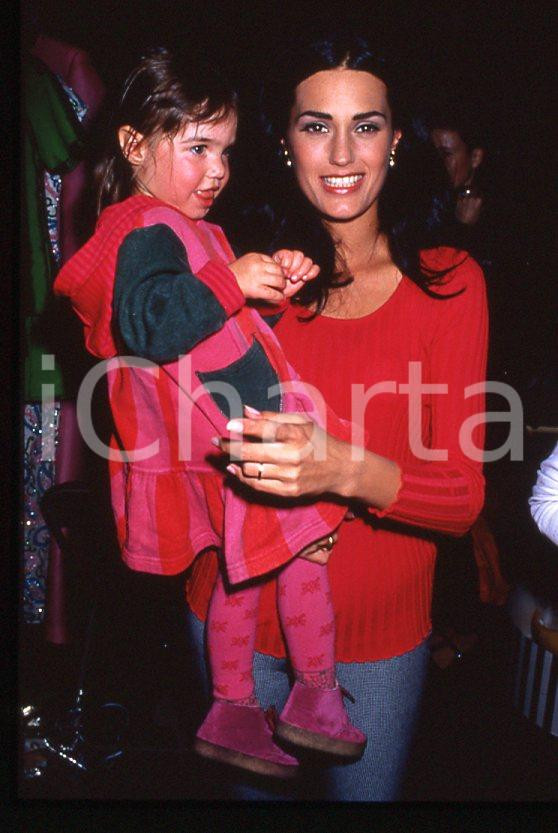 Yasmin LE BON and daughter - 1990 ca *35 mm vintage slide 1 Diapositiva d'epoca, in formato 35 mm.Per i diritti rivolgersi a ICharta.E' severamente vietata la riproduzione. Tutti i diritti sono riservati.ICharta mette in vendita, sul negozio eBay e in esclusiva sul sito "icharta" il proprio archivio composto da numerose diapositive e negativi fotografici d'epoca, tutti originali e autentici, che attraversano la storia del costume tra la fine degli anni Sessanta e Novanta.Si tratta di uno sguardo inedito sull'attualità, la politica, la vita quotidiana, il gossip e la cultura, che fotografa il cambiamento della nazione in quest'ultimo scorcio del XX secolo. Un'occasione unica per il mercato del collezionismo, che vede finalmente disponibile un archivio eccezionale per vastità, tematiche e condizioni, in un settore (il negativo fotografico e la diapositiva) di assoluta novità e dalle interessanti prospettive di investimento.  GOOD/buono   originale e autentica 1