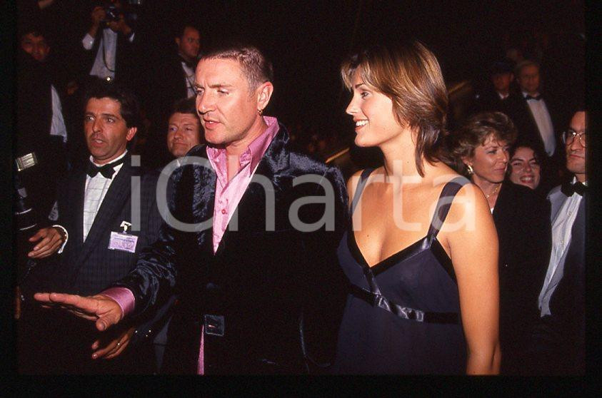 Simon LE BON (DURAN DURAN) Yasmin - 1995 ca *35 mm vintage slide (12) Diapositiva d'epoca, in formato 35 mm.Si tratta della première del film "The Fugitive".Per i diritti rivolgersi a ICharta.E' severamente vietata la riproduzione. Tutti i diritti sono riservati.ICharta mette in vendita, sul negozio eBay e in esclusiva sul sito "icharta" il proprio archivio composto da numerose diapositive e negativi fotografici d'epoca, tutti originali e autentici, che attraversano la storia del costume tra la fine degli anni Sessanta e Novanta.Si tratta di uno sguardo inedito sull'attualità, la politica, la vita quotidiana, il gossip e la cultura, che fotografa il cambiamento della nazione in quest'ultimo scorcio del XX secolo. Un'occasione unica per il mercato del collezionismo, che vede finalmente disponibile un archivio eccezionale per vastità, tematiche e condizioni, in un settore (il negativo fotografico e la diapositiva) di assoluta novità e dalle interessanti prospettive di investimento.  GOOD/buono   originale e autentica 1