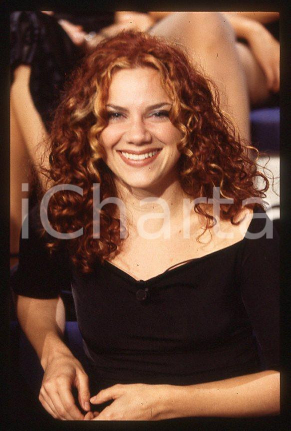 Nikka COSTA cantante - "Meteore" TV 1998 *35 mm vintage slide (2) Diapositiva d'epoca, in formato 35 mm.Per i diritti rivolgersi a ICharta.E' severamente vietata la riproduzione. Tutti i diritti sono riservati.ICharta mette in vendita, sul negozio eBay e in esclusiva sul sito "icharta" il proprio archivio composto da numerose diapositive e negativi fotografici d'epoca, tutti originali e autentici, che attraversano la storia del costume tra la fine degli anni Sessanta e Novanta.Si tratta di uno sguardo inedito sull'attualità, la politica, la vita quotidiana, il gossip e la cultura, che fotografa il cambiamento della nazione in quest'ultimo scorcio del XX secolo. Un'occasione unica per il mercato del collezionismo, che vede finalmente disponibile un archivio eccezionale per vastità, tematiche e condizioni, in un settore (il negativo fotografico e la diapositiva) di assoluta novità e dalle interessanti prospettive di investimento.  GOOD/buono   originale e autentica 1