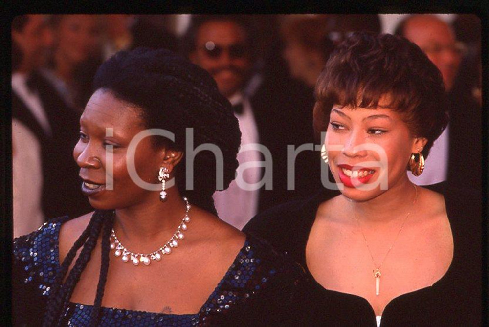 Whoopi GOLDBERG Alex MARTIN daughter - 63rd Oscars 1991 *35mm vintage slide 1  Diapositiva originale, in formato 35 mm.  CONDIZIONI: GOODE' severamente vietata la riproduzione. Tutti i diritti sono riservati. ICharta mette in vendita, sul negozio eBay e in esclusiva sul sito "icharta" il proprio archivio composto da numerose diapositive e negativi fotografici d'epoca, tutti originali e autentici, che attraversano la storia del costume tra la fine degli anni Sessanta e Novanta.Si tratta di uno sguardo inedito sull'attualità, la politica, la vita quotidiana, il gossip e la cultura, che fotografa il cambiamento della nazione in quest'ultimo scorcio del XX secolo. Un'occasione unica per il mercato del collezionismo, che vede finalmente disponibile un archivio eccezionale per vastità, tematiche e condizioni, in un settore (il negativo fotografico e la diapositiva) di assoluta novità e dalle interessanti prospettive di investimento.    originale e autentica 1
