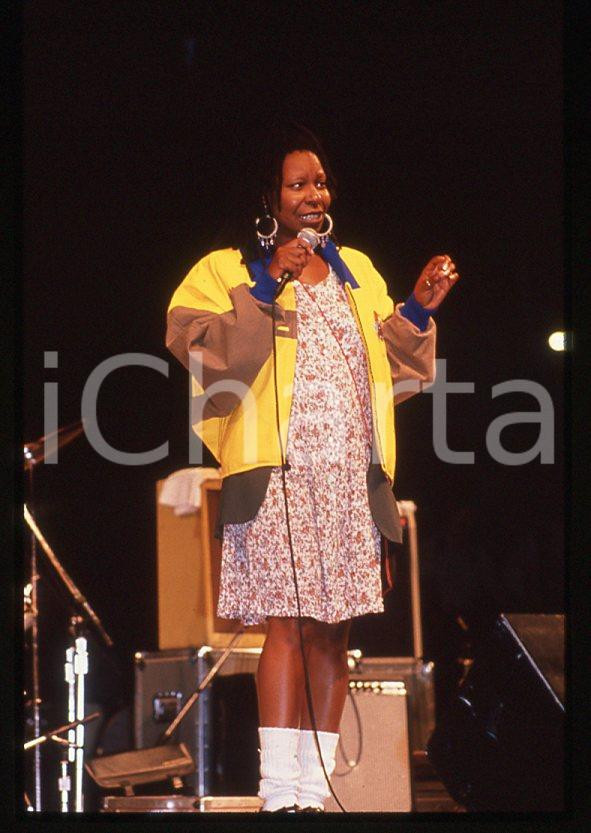 Whoopi GOLDBERG sul palco - 1990 ca *35mm vintage slide (1)  Diapositiva originale, in formato 35 mm.  CONDIZIONI: GOODE' severamente vietata la riproduzione. Tutti i diritti sono riservati. ICharta mette in vendita, sul negozio eBay e in esclusiva sul sito "icharta" il proprio archivio composto da numerose diapositive e negativi fotografici d'epoca, tutti originali e autentici, che attraversano la storia del costume tra la fine degli anni Sessanta e Novanta.Si tratta di uno sguardo inedito sull'attualità, la politica, la vita quotidiana, il gossip e la cultura, che fotografa il cambiamento della nazione in quest'ultimo scorcio del XX secolo. Un'occasione unica per il mercato del collezionismo, che vede finalmente disponibile un archivio eccezionale per vastità, tematiche e condizioni, in un settore (il negativo fotografico e la diapositiva) di assoluta novità e dalle interessanti prospettive di investimento.    originale e autentica 1