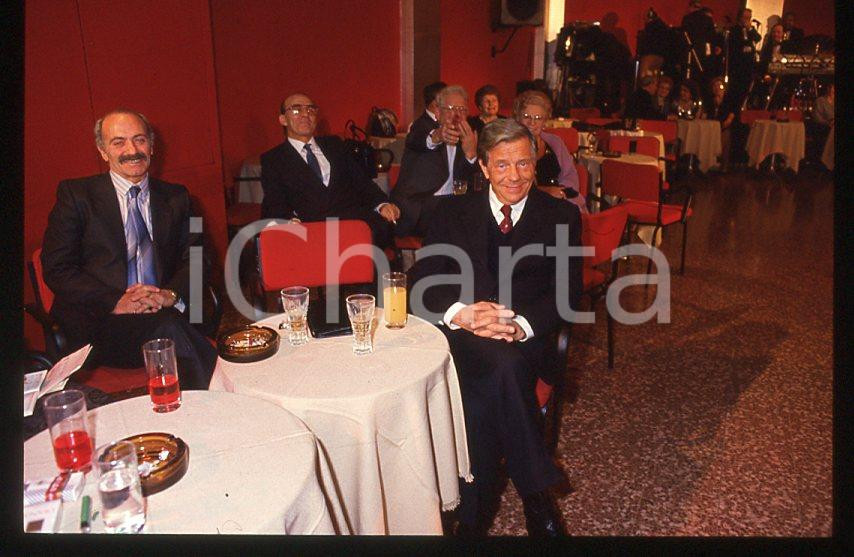 Renzo PALMER "Cuore di mamma" 1988 - A tavola *35mm vintage slide (1) Diapositiva originale, in formato 35 mm.Per i diritti rivolgersi a ICharta.E' severamente vietata la riproduzione. Tutti i diritti sono riservati.ICharta mette in vendita, sul negozio eBay e in esclusiva sul sito "icharta" il proprio archivio composto da numerose diapositive e negativi fotografici d'epoca, tutti originali e autentici, che attraversano la storia del costume tra la fine degli anni Sessanta e Novanta.Si tratta di uno sguardo inedito sull'attualità, la politica, la vita quotidiana, il gossip e la cultura, che fotografa il cambiamento della nazione in quest'ultimo scorcio del XX secolo. Un'occasione unica per il mercato del collezionismo, che vede finalmente disponibile un archivio eccezionale per vastità, tematiche e condizioni, in un settore (il negativo fotografico e la diapositiva) di assoluta novità e dalle interessanti prospettive di investimento.  GOOD/buono   originale e autentica 1