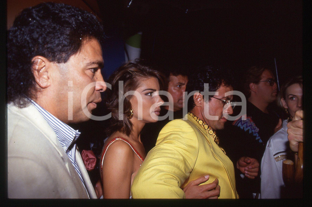 Sylvester STALLONE e Jennifer FLAVIN - COSTUME 1995 ca 35 mm vintage slide 21 Diapositiva d'epoca, in formato 35 mm.CONDIZIONI: GOODE' severamente vietata la riproduzione. Tutti i diritti sono riservati.Nella diapositiva ICharta mette in vendita, sul negozio eBay e in esclusiva sul sito "icharta" il proprio archivio composto da numerose diapositive e negativi fotografici d'epoca, tutti originali e autentici, che attraversano la storia del costume italiano tra gli la fine degli anni Sessanta e Novanta.Si tratta di uno sguardo inedito sull'attualità, la politica, la vita quotidiana, il gossip e la cultura, che fotografa il cambiamento della nazione in quest'ultimo scorcio del XX secolo. Un'occasione unica per il mercato del collezionismo, che vede finalmente disponibile un archivio eccezionale per vastità, tematiche e condizioni, in un settore (il negativo fotografico e la diapositiva) di assoluta novità e dalle interessanti prospettive di investimento.  GOOD/buono   originale e autentica 1