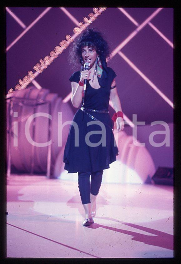 1985 ca MUSICA Teresa DE SIO * 35 mm vintage slide (11) Diapositiva d'epoca, in formato 35 mm.CONDIZIONI: GOODE' severamente vietata la riproduzione. Tutti i diritti sono riservati.ICharta mette in vendita, sul negozio eBay e in esclusiva sul sito "icharta" il proprio archivio composto da numerose diapositive e negativi fotografici d'epoca, tutti originali e autentici, che attraversano la storia del costume italiano tra gli la fine degli anni Sessanta e Novanta.Si tratta di uno sguardo inedito sull'attualità , la politica, la vita quotidiana, il gossip e la cultura, che fotografa il cambiamento della nazione in quest'ultimo scorcio del XX secolo. Un'occasione unica per il mercato del collezionismo, che vede finalmente disponibile un archivio eccezionale per vastità , tematiche e condizioni, in un settore (il negativo fotografico e la diapositiva) di assoluta novità e dalle interessanti prospettive di investimento. GOOD/buono   originale e autentica 1