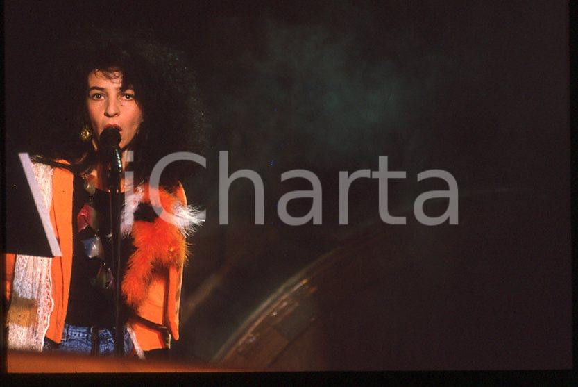 1985 ca MUSICA Teresa DE SIO * 35 mm vintage slide (14) Diapositiva d'epoca, in formato 35 mm.CONDIZIONI: GOODE' severamente vietata la riproduzione. Tutti i diritti sono riservati.ICharta mette in vendita, sul negozio eBay e in esclusiva sul sito "icharta" il proprio archivio composto da numerose diapositive e negativi fotografici d'epoca, tutti originali e autentici, che attraversano la storia del costume italiano tra gli la fine degli anni Sessanta e Novanta.Si tratta di uno sguardo inedito sull'attualità , la politica, la vita quotidiana, il gossip e la cultura, che fotografa il cambiamento della nazione in quest'ultimo scorcio del XX secolo. Un'occasione unica per il mercato del collezionismo, che vede finalmente disponibile un archivio eccezionale per vastità , tematiche e condizioni, in un settore (il negativo fotografico e la diapositiva) di assoluta novità e dalle interessanti prospettive di investimento. GOOD/buono   originale e autentica 1