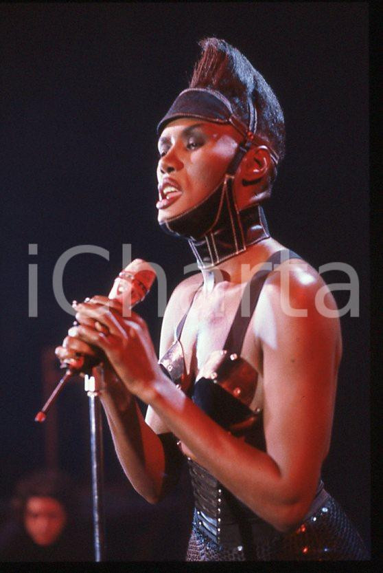1985 ca MUSICA Grace JONES durante un concerto * 35 mm vintage slide (1) Diapositiva d'epoca, in formato 35 mm.CONDIZIONI: GOODE' severamente vietata la riproduzione. Tutti i diritti sono riservati.ICharta mette in vendita, sul negozio eBay e in esclusiva sul sito "icharta" il proprio archivio composto da numerose diapositive e negativi fotografici d'epoca, tutti originali e autentici, che attraversano la storia del costume italiano tra gli la fine degli anni Sessanta e Novanta.Si tratta di uno sguardo inedito sull'attualità , la politica, la vita quotidiana, il gossip e la cultura, che fotografa il cambiamento della nazione in quest'ultimo scorcio del XX secolo. Un'occasione unica per il mercato del collezionismo, che vede finalmente disponibile un archivio eccezionale per vastità , tematiche e condizioni, in un settore (il negativo fotografico e la diapositiva) di assoluta novità e dalle interessanti prospettive di investimento. GOOD/buono   originale e autentica 1