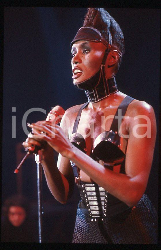 1985 ca MUSICA Grace JONES durante un concerto * 35 mm vintage slide (6) Diapositiva d'epoca, in formato 35 mm.CONDIZIONI: GOODE' severamente vietata la riproduzione. Tutti i diritti sono riservati.ICharta mette in vendita, sul negozio eBay e in esclusiva sul sito "icharta" il proprio archivio composto da numerose diapositive e negativi fotografici d'epoca, tutti originali e autentici, che attraversano la storia del costume italiano tra gli la fine degli anni Sessanta e Novanta.Si tratta di uno sguardo inedito sull'attualità , la politica, la vita quotidiana, il gossip e la cultura, che fotografa il cambiamento della nazione in quest'ultimo scorcio del XX secolo. Un'occasione unica per il mercato del collezionismo, che vede finalmente disponibile un archivio eccezionale per vastità , tematiche e condizioni, in un settore (il negativo fotografico e la diapositiva) di assoluta novità e dalle interessanti prospettive di investimento. GOOD/buono   originale e autentica 1