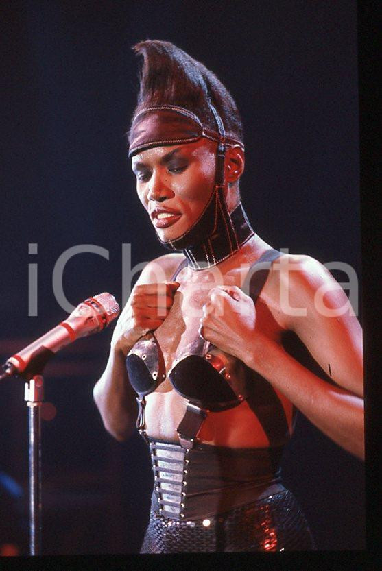 1985 ca MUSICA Grace JONES durante un concerto * 35 mm vintage slide (7) Diapositiva d'epoca, in formato 35 mm.CONDIZIONI: GOODE' severamente vietata la riproduzione. Tutti i diritti sono riservati.ICharta mette in vendita, sul negozio eBay e in esclusiva sul sito "icharta" il proprio archivio composto da numerose diapositive e negativi fotografici d'epoca, tutti originali e autentici, che attraversano la storia del costume italiano tra gli la fine degli anni Sessanta e Novanta.Si tratta di uno sguardo inedito sull'attualità , la politica, la vita quotidiana, il gossip e la cultura, che fotografa il cambiamento della nazione in quest'ultimo scorcio del XX secolo. Un'occasione unica per il mercato del collezionismo, che vede finalmente disponibile un archivio eccezionale per vastità , tematiche e condizioni, in un settore (il negativo fotografico e la diapositiva) di assoluta novità e dalle interessanti prospettive di investimento. GOOD/buono   originale e autentica 1