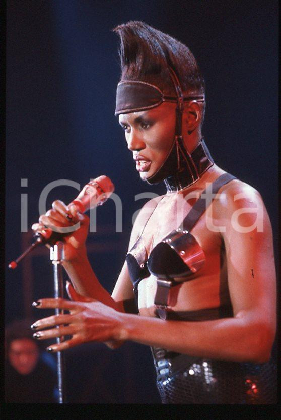 1985 ca MUSICA Grace JONES durante un concerto * 35 mm vintage slide (11) Diapositiva d'epoca, in formato 35 mm.CONDIZIONI: GOODE' severamente vietata la riproduzione. Tutti i diritti sono riservati.ICharta mette in vendita, sul negozio eBay e in esclusiva sul sito "icharta" il proprio archivio composto da numerose diapositive e negativi fotografici d'epoca, tutti originali e autentici, che attraversano la storia del costume italiano tra gli la fine degli anni Sessanta e Novanta.Si tratta di uno sguardo inedito sull'attualità , la politica, la vita quotidiana, il gossip e la cultura, che fotografa il cambiamento della nazione in quest'ultimo scorcio del XX secolo. Un'occasione unica per il mercato del collezionismo, che vede finalmente disponibile un archivio eccezionale per vastità , tematiche e condizioni, in un settore (il negativo fotografico e la diapositiva) di assoluta novità e dalle interessanti prospettive di investimento. GOOD/buono   originale e autentica 1