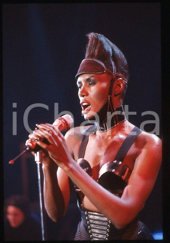 1985 ca MUSICA Grace JONES durante un concerto * 35 mm vintage slide (9) Diapositiva d'epoca, in formato 35 mm.CONDIZIONI: GOODE' severamente vietata la riproduzione. Tutti i diritti sono riservati.ICharta mette in vendita, sul negozio eBay e in esclusiva sul sito "icharta" il proprio archivio composto da numerose diapositive e negativi fotografici d'epoca, tutti originali e autentici, che attraversano la storia del costume italiano tra gli la fine degli anni Sessanta e Novanta.Si tratta di uno sguardo inedito sull'attualità , la politica, la vita quotidiana, il gossip e la cultura, che fotografa il cambiamento della nazione in quest'ultimo scorcio del XX secolo. Un'occasione unica per il mercato del collezionismo, che vede finalmente disponibile un archivio eccezionale per vastità , tematiche e condizioni, in un settore (il negativo fotografico e la diapositiva) di assoluta novità e dalle interessanti prospettive di investimento. GOOD/buono   originale e autentica 1