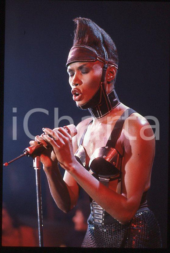 1985 ca MUSICA Grace JONES durante un concerto * 35 mm vintage slide (8) Diapositiva d'epoca, in formato 35 mm.CONDIZIONI: GOODE' severamente vietata la riproduzione. Tutti i diritti sono riservati.ICharta mette in vendita, sul negozio eBay e in esclusiva sul sito "icharta" il proprio archivio composto da numerose diapositive e negativi fotografici d'epoca, tutti originali e autentici, che attraversano la storia del costume italiano tra gli la fine degli anni Sessanta e Novanta.Si tratta di uno sguardo inedito sull'attualità , la politica, la vita quotidiana, il gossip e la cultura, che fotografa il cambiamento della nazione in quest'ultimo scorcio del XX secolo. Un'occasione unica per il mercato del collezionismo, che vede finalmente disponibile un archivio eccezionale per vastità , tematiche e condizioni, in un settore (il negativo fotografico e la diapositiva) di assoluta novità e dalle interessanti prospettive di investimento. GOOD/buono   originale e autentica 1