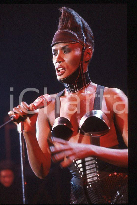 1985 ca MUSICA Grace JONES durante un concerto * 35 mm vintage slide (18) Diapositiva d'epoca, in formato 35 mm.CONDIZIONI: GOODE' severamente vietata la riproduzione. Tutti i diritti sono riservati.ICharta mette in vendita, sul negozio eBay e in esclusiva sul sito "icharta" il proprio archivio composto da numerose diapositive e negativi fotografici d'epoca, tutti originali e autentici, che attraversano la storia del costume italiano tra gli la fine degli anni Sessanta e Novanta.Si tratta di uno sguardo inedito sull'attualità , la politica, la vita quotidiana, il gossip e la cultura, che fotografa il cambiamento della nazione in quest'ultimo scorcio del XX secolo. Un'occasione unica per il mercato del collezionismo, che vede finalmente disponibile un archivio eccezionale per vastità , tematiche e condizioni, in un settore (il negativo fotografico e la diapositiva) di assoluta novità e dalle interessanti prospettive di investimento. GOOD/buono   originale e autentica 1