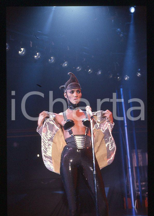 1985 ca MUSICA Grace JONES durante un concerto * 35 mm vintage slide (40) Diapositiva d'epoca, in formato 35 mm.CONDIZIONI: GOODE' severamente vietata la riproduzione. Tutti i diritti sono riservati.ICharta mette in vendita, sul negozio eBay e in esclusiva sul sito "icharta" il proprio archivio composto da numerose diapositive e negativi fotografici d'epoca, tutti originali e autentici, che attraversano la storia del costume italiano tra gli la fine degli anni Sessanta e Novanta.Si tratta di uno sguardo inedito sull'attualità , la politica, la vita quotidiana, il gossip e la cultura, che fotografa il cambiamento della nazione in quest'ultimo scorcio del XX secolo. Un'occasione unica per il mercato del collezionismo, che vede finalmente disponibile un archivio eccezionale per vastità , tematiche e condizioni, in un settore (il negativo fotografico e la diapositiva) di assoluta novità e dalle interessanti prospettive di investimento. GOOD/buono   originale e autentica 1