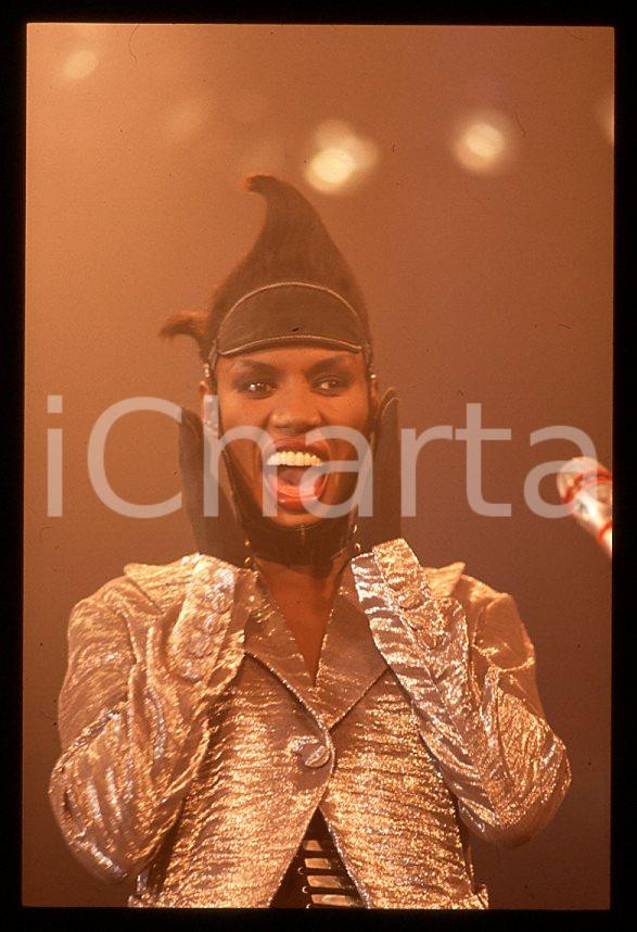1985 ca MUSICA Grace JONES durante un concerto * 35 mm vintage slide (46) Diapositiva d'epoca, in formato 35 mm.CONDIZIONI: GOODE' severamente vietata la riproduzione. Tutti i diritti sono riservati.ICharta mette in vendita, sul negozio eBay e in esclusiva sul sito "icharta" il proprio archivio composto da numerose diapositive e negativi fotografici d'epoca, tutti originali e autentici, che attraversano la storia del costume italiano tra gli la fine degli anni Sessanta e Novanta.Si tratta di uno sguardo inedito sull'attualità , la politica, la vita quotidiana, il gossip e la cultura, che fotografa il cambiamento della nazione in quest'ultimo scorcio del XX secolo. Un'occasione unica per il mercato del collezionismo, che vede finalmente disponibile un archivio eccezionale per vastità , tematiche e condizioni, in un settore (il negativo fotografico e la diapositiva) di assoluta novità e dalle interessanti prospettive di investimento. GOOD/buono   originale e autentica 1