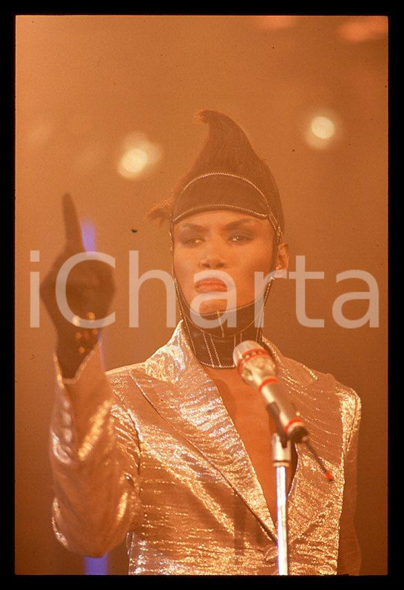 1985 ca MUSICA Grace JONES durante un concerto * 35 mm vintage slide (51) Diapositiva d'epoca, in formato 35 mm.CONDIZIONI: GOODE' severamente vietata la riproduzione. Tutti i diritti sono riservati.ICharta mette in vendita, sul negozio eBay e in esclusiva sul sito "icharta" il proprio archivio composto da numerose diapositive e negativi fotografici d'epoca, tutti originali e autentici, che attraversano la storia del costume italiano tra gli la fine degli anni Sessanta e Novanta.Si tratta di uno sguardo inedito sull'attualità , la politica, la vita quotidiana, il gossip e la cultura, che fotografa il cambiamento della nazione in quest'ultimo scorcio del XX secolo. Un'occasione unica per il mercato del collezionismo, che vede finalmente disponibile un archivio eccezionale per vastità , tematiche e condizioni, in un settore (il negativo fotografico e la diapositiva) di assoluta novità e dalle interessanti prospettive di investimento. GOOD/buono   originale e autentica 1