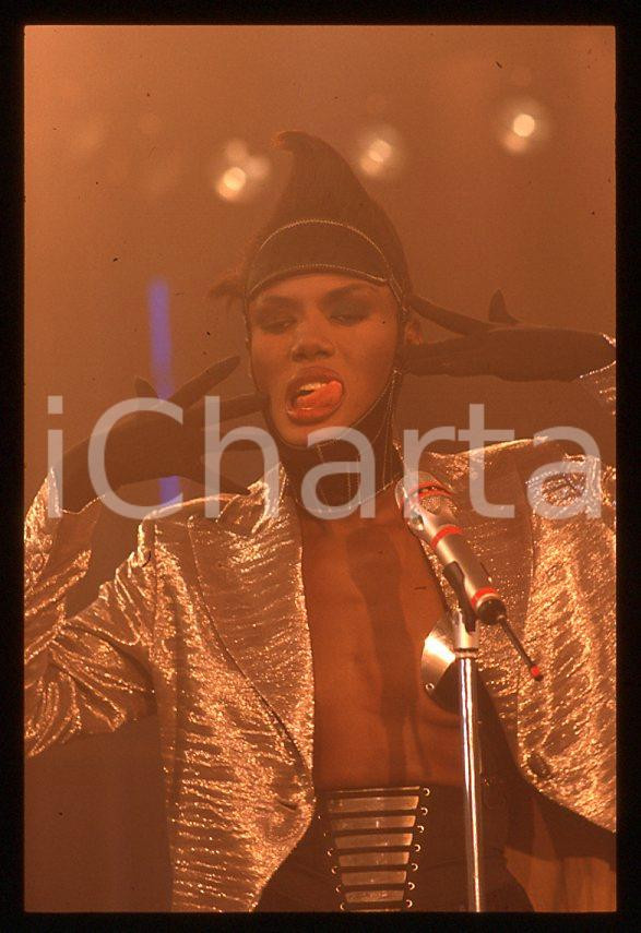 1985 ca MUSICA Grace JONES durante un concerto * 35 mm vintage slide (52) Diapositiva d'epoca, in formato 35 mm.CONDIZIONI: GOODE' severamente vietata la riproduzione. Tutti i diritti sono riservati.ICharta mette in vendita, sul negozio eBay e in esclusiva sul sito "icharta" il proprio archivio composto da numerose diapositive e negativi fotografici d'epoca, tutti originali e autentici, che attraversano la storia del costume italiano tra gli la fine degli anni Sessanta e Novanta.Si tratta di uno sguardo inedito sull'attualità , la politica, la vita quotidiana, il gossip e la cultura, che fotografa il cambiamento della nazione in quest'ultimo scorcio del XX secolo. Un'occasione unica per il mercato del collezionismo, che vede finalmente disponibile un archivio eccezionale per vastità , tematiche e condizioni, in un settore (il negativo fotografico e la diapositiva) di assoluta novità e dalle interessanti prospettive di investimento. GOOD/buono   originale e autentica 1