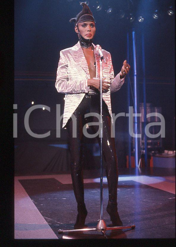 1985 ca MUSICA Grace JONES durante un concerto * 35 mm vintage slide (56) Diapositiva d'epoca, in formato 35 mm.CONDIZIONI: GOODE' severamente vietata la riproduzione. Tutti i diritti sono riservati.ICharta mette in vendita, sul negozio eBay e in esclusiva sul sito "icharta" il proprio archivio composto da numerose diapositive e negativi fotografici d'epoca, tutti originali e autentici, che attraversano la storia del costume italiano tra gli la fine degli anni Sessanta e Novanta.Si tratta di uno sguardo inedito sull'attualità , la politica, la vita quotidiana, il gossip e la cultura, che fotografa il cambiamento della nazione in quest'ultimo scorcio del XX secolo. Un'occasione unica per il mercato del collezionismo, che vede finalmente disponibile un archivio eccezionale per vastità , tematiche e condizioni, in un settore (il negativo fotografico e la diapositiva) di assoluta novità e dalle interessanti prospettive di investimento. GOOD/buono   originale e autentica 1