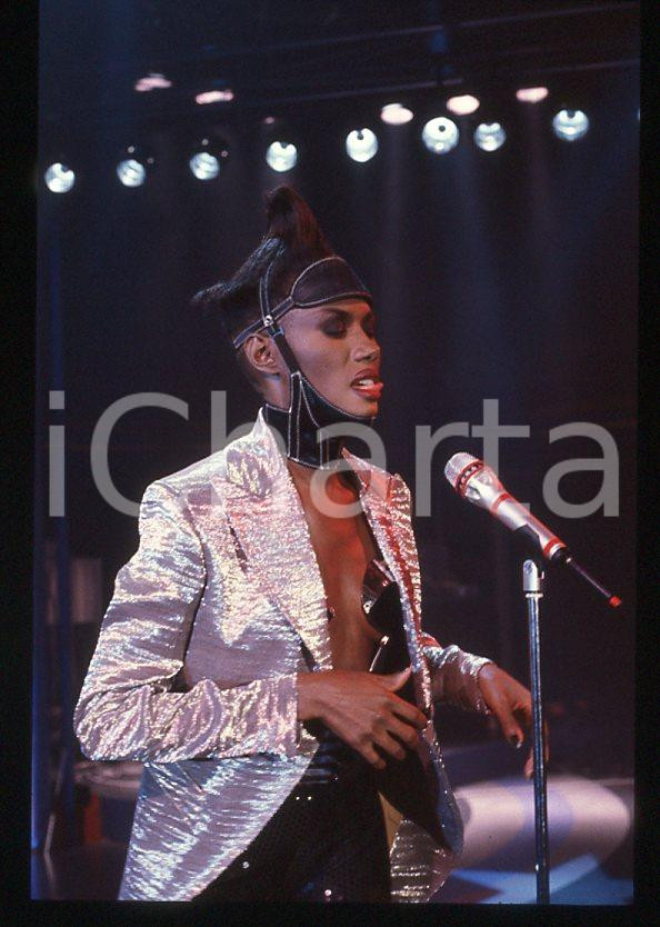1985 ca MUSICA Grace JONES durante un concerto * 35 mm vintage slide (62) Diapositiva d'epoca, in formato 35 mm.CONDIZIONI: GOODE' severamente vietata la riproduzione. Tutti i diritti sono riservati.ICharta mette in vendita, sul negozio eBay e in esclusiva sul sito "icharta" il proprio archivio composto da numerose diapositive e negativi fotografici d'epoca, tutti originali e autentici, che attraversano la storia del costume italiano tra gli la fine degli anni Sessanta e Novanta.Si tratta di uno sguardo inedito sull'attualità , la politica, la vita quotidiana, il gossip e la cultura, che fotografa il cambiamento della nazione in quest'ultimo scorcio del XX secolo. Un'occasione unica per il mercato del collezionismo, che vede finalmente disponibile un archivio eccezionale per vastità , tematiche e condizioni, in un settore (il negativo fotografico e la diapositiva) di assoluta novità e dalle interessanti prospettive di investimento. GOOD/buono   originale e autentica 1