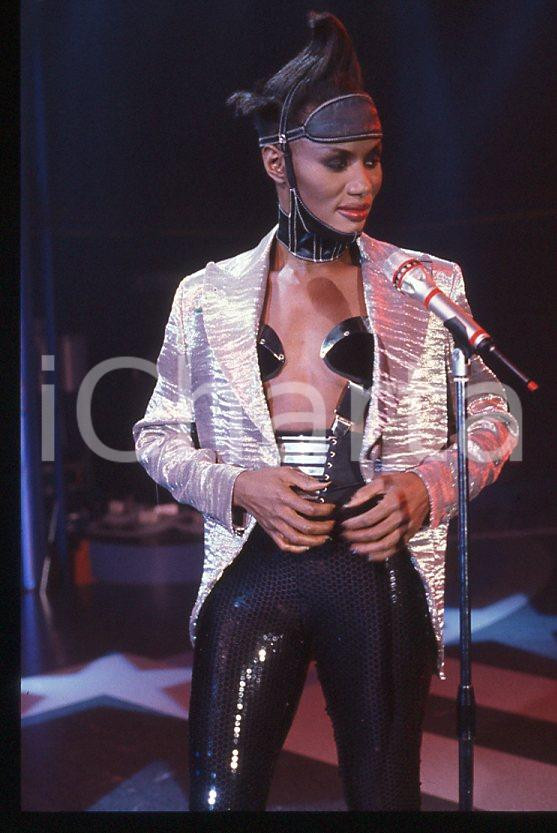 1985 ca MUSICA Grace JONES durante un concerto * 35 mm vintage slide (64) Diapositiva d'epoca, in formato 35 mm.CONDIZIONI: GOODE' severamente vietata la riproduzione. Tutti i diritti sono riservati.ICharta mette in vendita, sul negozio eBay e in esclusiva sul sito "icharta" il proprio archivio composto da numerose diapositive e negativi fotografici d'epoca, tutti originali e autentici, che attraversano la storia del costume italiano tra gli la fine degli anni Sessanta e Novanta.Si tratta di uno sguardo inedito sull'attualità , la politica, la vita quotidiana, il gossip e la cultura, che fotografa il cambiamento della nazione in quest'ultimo scorcio del XX secolo. Un'occasione unica per il mercato del collezionismo, che vede finalmente disponibile un archivio eccezionale per vastità , tematiche e condizioni, in un settore (il negativo fotografico e la diapositiva) di assoluta novità e dalle interessanti prospettive di investimento. GOOD/buono   originale e autentica 1