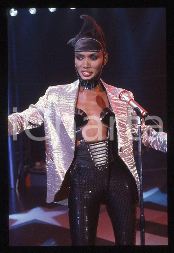 1985 ca MUSICA Grace JONES durante un concerto * 35 mm vintage slide (67) Diapositiva d'epoca, in formato 35 mm.CONDIZIONI: GOODE' severamente vietata la riproduzione. Tutti i diritti sono riservati.ICharta mette in vendita, sul negozio eBay e in esclusiva sul sito "icharta" il proprio archivio composto da numerose diapositive e negativi fotografici d'epoca, tutti originali e autentici, che attraversano la storia del costume italiano tra gli la fine degli anni Sessanta e Novanta.Si tratta di uno sguardo inedito sull'attualità , la politica, la vita quotidiana, il gossip e la cultura, che fotografa il cambiamento della nazione in quest'ultimo scorcio del XX secolo. Un'occasione unica per il mercato del collezionismo, che vede finalmente disponibile un archivio eccezionale per vastità , tematiche e condizioni, in un settore (il negativo fotografico e la diapositiva) di assoluta novità e dalle interessanti prospettive di investimento. GOOD/buono   originale e autentica 1