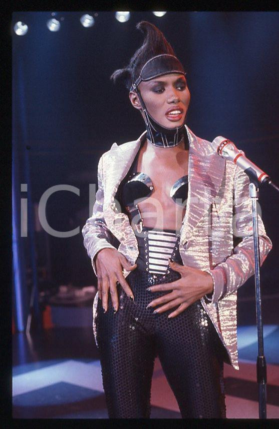 1985 ca MUSICA Grace JONES durante un concerto * 35 mm vintage slide (74) Diapositiva d'epoca, in formato 35 mm.CONDIZIONI: GOODE' severamente vietata la riproduzione. Tutti i diritti sono riservati.ICharta mette in vendita, sul negozio eBay e in esclusiva sul sito "icharta" il proprio archivio composto da numerose diapositive e negativi fotografici d'epoca, tutti originali e autentici, che attraversano la storia del costume italiano tra gli la fine degli anni Sessanta e Novanta.Si tratta di uno sguardo inedito sull'attualità , la politica, la vita quotidiana, il gossip e la cultura, che fotografa il cambiamento della nazione in quest'ultimo scorcio del XX secolo. Un'occasione unica per il mercato del collezionismo, che vede finalmente disponibile un archivio eccezionale per vastità , tematiche e condizioni, in un settore (il negativo fotografico e la diapositiva) di assoluta novità e dalle interessanti prospettive di investimento. GOOD/buono   originale e autentica 1