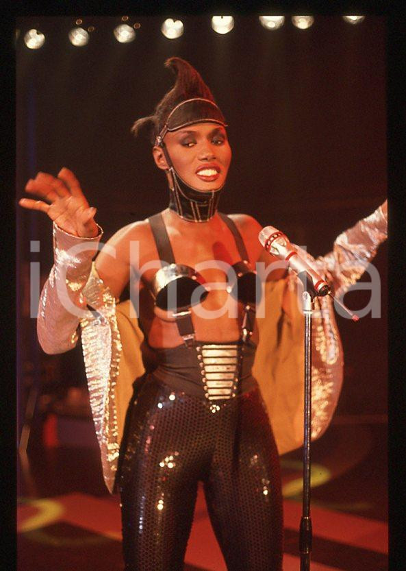 1985 ca MUSICA Grace JONES durante un concerto * 35 mm vintage slide (39) Diapositiva d'epoca, in formato 35 mm.CONDIZIONI: GOODE' severamente vietata la riproduzione. Tutti i diritti sono riservati.ICharta mette in vendita, sul negozio eBay e in esclusiva sul sito "icharta" il proprio archivio composto da numerose diapositive e negativi fotografici d'epoca, tutti originali e autentici, che attraversano la storia del costume italiano tra gli la fine degli anni Sessanta e Novanta.Si tratta di uno sguardo inedito sull'attualità , la politica, la vita quotidiana, il gossip e la cultura, che fotografa il cambiamento della nazione in quest'ultimo scorcio del XX secolo. Un'occasione unica per il mercato del collezionismo, che vede finalmente disponibile un archivio eccezionale per vastità , tematiche e condizioni, in un settore (il negativo fotografico e la diapositiva) di assoluta novità e dalle interessanti prospettive di investimento. GOOD/buono   originale e autentica 1