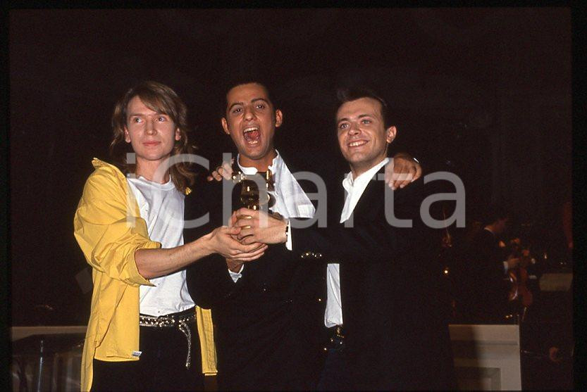 883 FIORELLO Max PEZZALI Festival Italiano 1993 - 35mm vintage slide 1 Diapositiva originale, in formato 35 mm.Scattata durante le riprese della trasmissione televisiva "Festival Italiano". Nella diapositive compare inoltre Mauro Repetto. Per i diritti rivolgersi a ICharta.E' severamente vietata la riproduzione. Tutti i diritti sono riservati.ICharta mette in vendita, sul negozio eBay e in esclusiva sul sito "icharta" il proprio archivio composto da numerose diapositive e negativi fotografici d'epoca, tutti originali e autentici, che attraversano la storia del costume tra la fine degli anni Sessanta e Novanta.Si tratta di uno sguardo inedito sull'attualità , la politica, la vita quotidiana, il gossip e la cultura, che fotografa il cambiamento della nazione in quest'ultimo scorcio del XX secolo.Un'occasione unica per il mercato del collezionismo, che vede finalmente disponibile un archivio eccezionale per vastità , tematiche e condizioni, in un settore (il negativo fotografico e la diapositiva) di assoluta novitÃ e dalle interessanti prospettive di investimento. GOOD/buono   originale e autentica 1