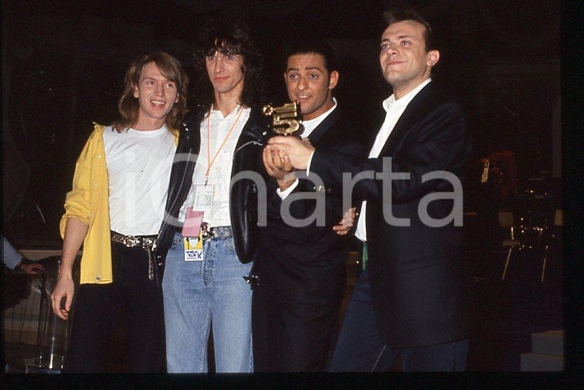 883 FIORELLO Max PEZZALI Festival Italiano 1993 - 35mm vintage slide 6 Diapositiva originale, in formato 35 mm.Scattata durante le riprese della trasmissione televisiva "Festival Italiano". Nella diapositive compare inoltre Mauro Repetto. Per i diritti rivolgersi a ICharta.E' severamente vietata la riproduzione. Tutti i diritti sono riservati.ICharta mette in vendita, sul negozio eBay e in esclusiva sul sito "icharta" il proprio archivio composto da numerose diapositive e negativi fotografici d'epoca, tutti originali e autentici, che attraversano la storia del costume tra la fine degli anni Sessanta e Novanta.Si tratta di uno sguardo inedito sull'attualità , la politica, la vita quotidiana, il gossip e la cultura, che fotografa il cambiamento della nazione in quest'ultimo scorcio del XX secolo.Un'occasione unica per il mercato del collezionismo, che vede finalmente disponibile un archivio eccezionale per vastità , tematiche e condizioni, in un settore (il negativo fotografico e la diapositiva) di assoluta novitÃ e dalle interessanti prospettive di investimento. GOOD/buono   originale e autentica 1