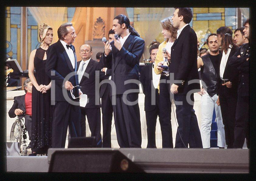 883 FIORELLO Max PEZZALI Festival Italiano 1993 - 35mm vintage slide 10 Diapositiva originale, in formato 35 mm.Scattata durante le riprese della trasmissione televisiva "Festival Italiano".Nella diapositive compare inoltre Mauro Repetto, Mike Bongiorno e Paola Barale.Per i diritti rivolgersi a ICharta.E' severamente vietata la riproduzione. Tutti i diritti sono riservati.ICharta mette in vendita, sul negozio eBay e in esclusiva sul sito "icharta" il proprio archivio composto da numerose diapositive e negativi fotografici d'epoca, tutti originali e autentici, che attraversano la storia del costume tra la fine degli anni Sessanta e Novanta.Si tratta di uno sguardo inedito sull'attualità , la politica, la vita quotidiana, il gossip e la cultura, che fotografa il cambiamento della nazione in quest'ultimo scorcio del XX secolo.Un'occasione unica per il mercato del collezionismo, che vede finalmente disponibile un archivio eccezionale per vastità , tematiche e condizioni, in un settore (il negativo fotografico e la diapositiva) di assoluta novitÃ e dalle interessanti prospettive di investimento. GOOD/buono   originale e autentica 1