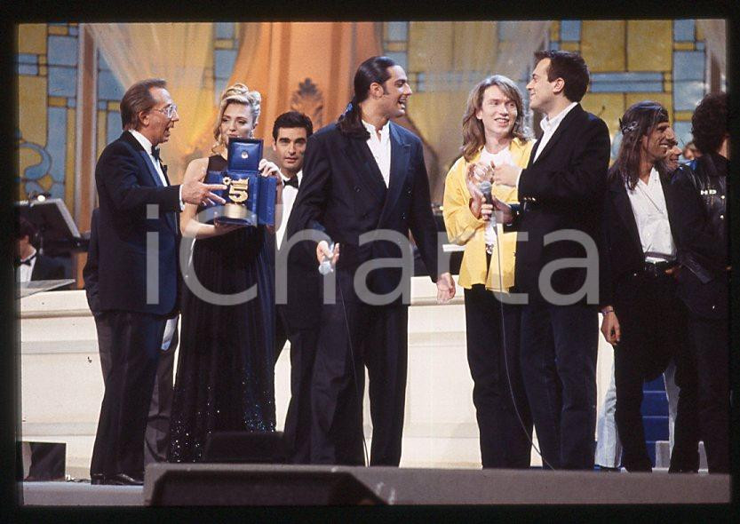 883 FIORELLO Max PEZZALI Festival Italiano 1993 - 35mm vintage slide 11 Diapositiva originale, in formato 35 mm.Scattata durante le riprese della trasmissione televisiva "Festival Italiano".Nella diapositive compare inoltre Mauro Repetto, Mike Bongiorno e Paola Barale.Per i diritti rivolgersi a ICharta.E' severamente vietata la riproduzione. Tutti i diritti sono riservati.ICharta mette in vendita, sul negozio eBay e in esclusiva sul sito "icharta" il proprio archivio composto da numerose diapositive e negativi fotografici d'epoca, tutti originali e autentici, che attraversano la storia del costume tra la fine degli anni Sessanta e Novanta.Si tratta di uno sguardo inedito sull'attualità , la politica, la vita quotidiana, il gossip e la cultura, che fotografa il cambiamento della nazione in quest'ultimo scorcio del XX secolo.Un'occasione unica per il mercato del collezionismo, che vede finalmente disponibile un archivio eccezionale per vastità , tematiche e condizioni, in un settore (il negativo fotografico e la diapositiva) di assoluta novitÃ e dalle interessanti prospettive di investimento. GOOD/buono   originale e autentica 1