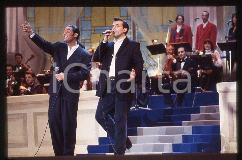 883 FIORELLO Max PEZZALI Festival Italiano 1993 - 35mm vintage slide 22 Diapositiva originale, in formato 35 mm.Scattata durante le riprese della trasmissione televisiva "Festival Italiano".Per i diritti rivolgersi a ICharta.E' severamente vietata la riproduzione. Tutti i diritti sono riservati.ICharta mette in vendita, sul negozio eBay e in esclusiva sul sito "icharta" il proprio archivio composto da numerose diapositive e negativi fotografici d'epoca, tutti originali e autentici, che attraversano la storia del costume tra la fine degli anni Sessanta e Novanta.Si tratta di uno sguardo inedito sull'attualità , la politica, la vita quotidiana, il gossip e la cultura, che fotografa il cambiamento della nazione in quest'ultimo scorcio del XX secolo.Un'occasione unica per il mercato del collezionismo, che vede finalmente disponibile un archivio eccezionale per vastità , tematiche e condizioni, in un settore (il negativo fotografico e la diapositiva) di assoluta novitÃ e dalle interessanti prospettive di investimento. GOOD/buono   originale e autentica 1