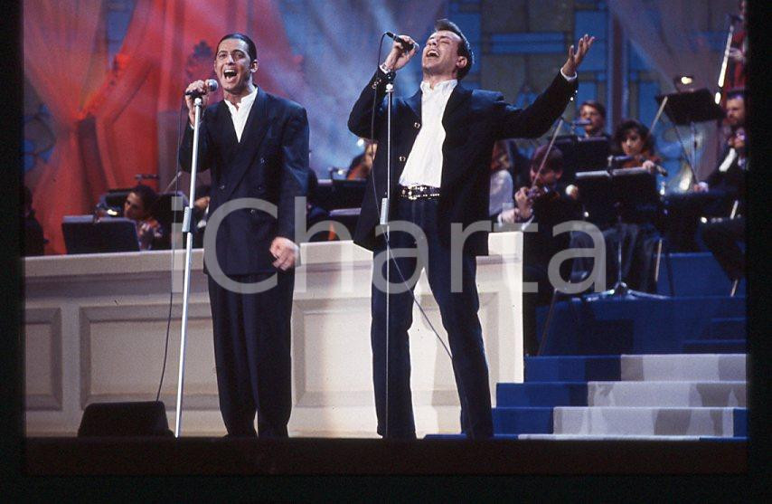 883 FIORELLO Max PEZZALI Festival Italiano 1993 - 35mm vintage slide 25 Diapositiva originale, in formato 35 mm.Scattata durante le riprese della trasmissione televisiva "Festival Italiano".Per i diritti rivolgersi a ICharta.E' severamente vietata la riproduzione. Tutti i diritti sono riservati.ICharta mette in vendita, sul negozio eBay e in esclusiva sul sito "icharta" il proprio archivio composto da numerose diapositive e negativi fotografici d'epoca, tutti originali e autentici, che attraversano la storia del costume tra la fine degli anni Sessanta e Novanta.Si tratta di uno sguardo inedito sull'attualità , la politica, la vita quotidiana, il gossip e la cultura, che fotografa il cambiamento della nazione in quest'ultimo scorcio del XX secolo.Un'occasione unica per il mercato del collezionismo, che vede finalmente disponibile un archivio eccezionale per vastità , tematiche e condizioni, in un settore (il negativo fotografico e la diapositiva) di assoluta novitÃ e dalle interessanti prospettive di investimento. GOOD/buono   originale e autentica 1