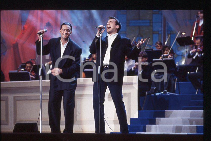 883 FIORELLO Max PEZZALI Festival Italiano 1993 - 35mm vintage slide 27 Diapositiva originale, in formato 35 mm.Scattata durante le riprese della trasmissione televisiva "Festival Italiano".Per i diritti rivolgersi a ICharta.E' severamente vietata la riproduzione. Tutti i diritti sono riservati.ICharta mette in vendita, sul negozio eBay e in esclusiva sul sito "icharta" il proprio archivio composto da numerose diapositive e negativi fotografici d'epoca, tutti originali e autentici, che attraversano la storia del costume tra la fine degli anni Sessanta e Novanta.Si tratta di uno sguardo inedito sull'attualità , la politica, la vita quotidiana, il gossip e la cultura, che fotografa il cambiamento della nazione in quest'ultimo scorcio del XX secolo.Un'occasione unica per il mercato del collezionismo, che vede finalmente disponibile un archivio eccezionale per vastità , tematiche e condizioni, in un settore (il negativo fotografico e la diapositiva) di assoluta novitÃ e dalle interessanti prospettive di investimento. GOOD/buono   originale e autentica 1