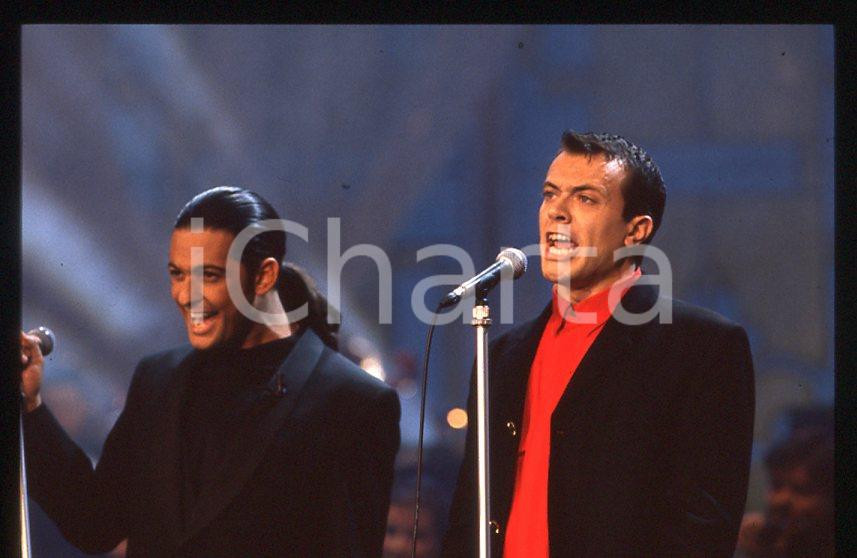 883 FIORELLO Max PEZZALI Festival Italiano 1993 - 35mm vintage slide 33 Diapositiva originale, in formato 35 mm.Scattata durante le riprese della trasmissione televisiva "Festival Italiano".Per i diritti rivolgersi a ICharta.E' severamente vietata la riproduzione. Tutti i diritti sono riservati.ICharta mette in vendita, sul negozio eBay e in esclusiva sul sito "icharta" il proprio archivio composto da numerose diapositive e negativi fotografici d'epoca, tutti originali e autentici, che attraversano la storia del costume tra la fine degli anni Sessanta e Novanta.Si tratta di uno sguardo inedito sull'attualità , la politica, la vita quotidiana, il gossip e la cultura, che fotografa il cambiamento della nazione in quest'ultimo scorcio del XX secolo.Un'occasione unica per il mercato del collezionismo, che vede finalmente disponibile un archivio eccezionale per vastità , tematiche e condizioni, in un settore (il negativo fotografico e la diapositiva) di assoluta novitÃ e dalle interessanti prospettive di investimento. GOOD/buono   originale e autentica 1