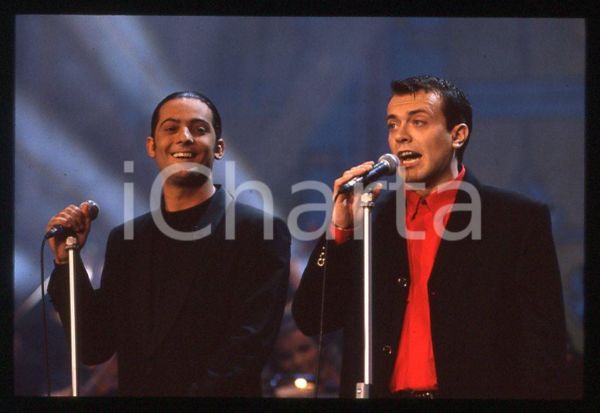 883 FIORELLO Max PEZZALI Festival Italiano 1993 - 35mm vintage slide 31 Diapositiva originale, in formato 35 mm.Scattata durante le riprese della trasmissione televisiva "Festival Italiano".Per i diritti rivolgersi a ICharta.E' severamente vietata la riproduzione. Tutti i diritti sono riservati.ICharta mette in vendita, sul negozio eBay e in esclusiva sul sito "icharta" il proprio archivio composto da numerose diapositive e negativi fotografici d'epoca, tutti originali e autentici, che attraversano la storia del costume tra la fine degli anni Sessanta e Novanta.Si tratta di uno sguardo inedito sull'attualità , la politica, la vita quotidiana, il gossip e la cultura, che fotografa il cambiamento della nazione in quest'ultimo scorcio del XX secolo.Un'occasione unica per il mercato del collezionismo, che vede finalmente disponibile un archivio eccezionale per vastità , tematiche e condizioni, in un settore (il negativo fotografico e la diapositiva) di assoluta novitÃ e dalle interessanti prospettive di investimento. GOOD/buono   originale e autentica 1