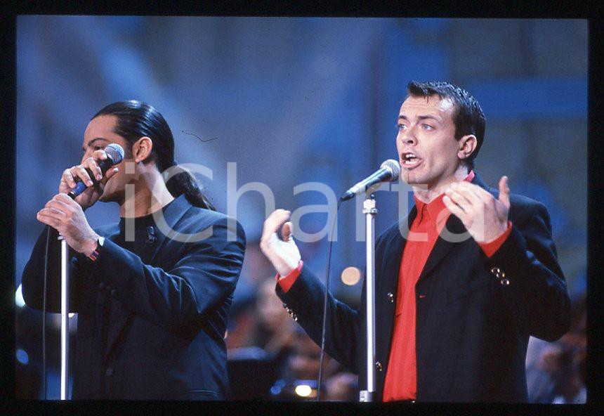 883 FIORELLO Max PEZZALI Festival Italiano 1993 - 35mm vintage slide 30 Diapositiva originale, in formato 35 mm.Scattata durante le riprese della trasmissione televisiva "Festival Italiano".Per i diritti rivolgersi a ICharta.E' severamente vietata la riproduzione. Tutti i diritti sono riservati.ICharta mette in vendita, sul negozio eBay e in esclusiva sul sito "icharta" il proprio archivio composto da numerose diapositive e negativi fotografici d'epoca, tutti originali e autentici, che attraversano la storia del costume tra la fine degli anni Sessanta e Novanta.Si tratta di uno sguardo inedito sull'attualità , la politica, la vita quotidiana, il gossip e la cultura, che fotografa il cambiamento della nazione in quest'ultimo scorcio del XX secolo.Un'occasione unica per il mercato del collezionismo, che vede finalmente disponibile un archivio eccezionale per vastità , tematiche e condizioni, in un settore (il negativo fotografico e la diapositiva) di assoluta novitÃ e dalle interessanti prospettive di investimento. GOOD/buono   originale e autentica 1