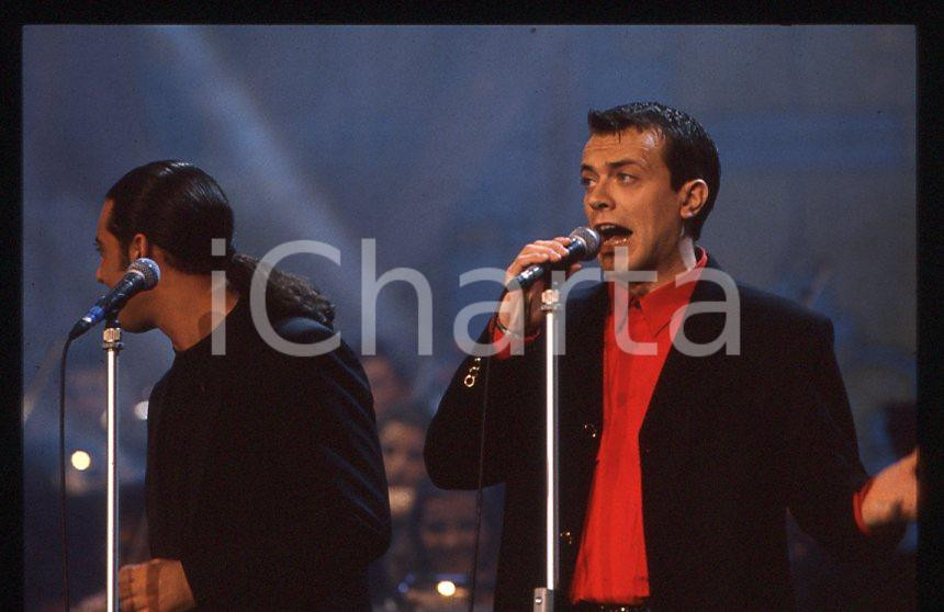 883 FIORELLO Max PEZZALI Festival Italiano 1993 - 35mm vintage slide 35 Diapositiva originale, in formato 35 mm.Scattata durante le riprese della trasmissione televisiva "Festival Italiano".Per i diritti rivolgersi a ICharta.E' severamente vietata la riproduzione. Tutti i diritti sono riservati.ICharta mette in vendita, sul negozio eBay e in esclusiva sul sito "icharta" il proprio archivio composto da numerose diapositive e negativi fotografici d'epoca, tutti originali e autentici, che attraversano la storia del costume tra la fine degli anni Sessanta e Novanta.Si tratta di uno sguardo inedito sull'attualità , la politica, la vita quotidiana, il gossip e la cultura, che fotografa il cambiamento della nazione in quest'ultimo scorcio del XX secolo.Un'occasione unica per il mercato del collezionismo, che vede finalmente disponibile un archivio eccezionale per vastità , tematiche e condizioni, in un settore (il negativo fotografico e la diapositiva) di assoluta novitÃ e dalle interessanti prospettive di investimento. GOOD/buono   originale e autentica 1