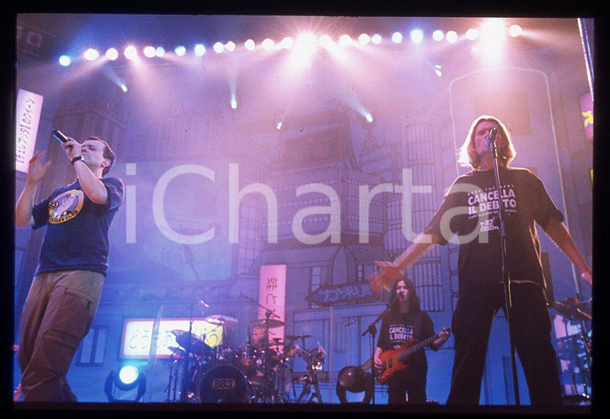 883 Max PEZZALI Grazie mille tour 1999 - 35mm vintage slide (30) Diapositiva originale, in formato 35 mm.Per i diritti rivolgersi a ICharta.E' severamente vietata la riproduzione. Tutti i diritti sono riservati.ICharta mette in vendita, sul negozio eBay e in esclusiva sul sito "icharta" il proprio archivio composto da numerose diapositive e negativi fotografici d'epoca, tutti originali e autentici, che attraversano la storia del costume tra la fine degli anni Sessanta e Novanta.Si tratta di uno sguardo inedito sull'attualità , la politica, la vita quotidiana, il gossip e la cultura, che fotografa il cambiamento della nazione in quest'ultimo scorcio del XX secolo.Un'occasione unica per il mercato del collezionismo, che vede finalmente disponibile un archivio eccezionale per vastità , tematiche e condizioni, in un settore (il negativo fotografico e la diapositiva) di assoluta novità e dalle interessanti prospettive di investimento. GOOD/buono   originale e autentica 1