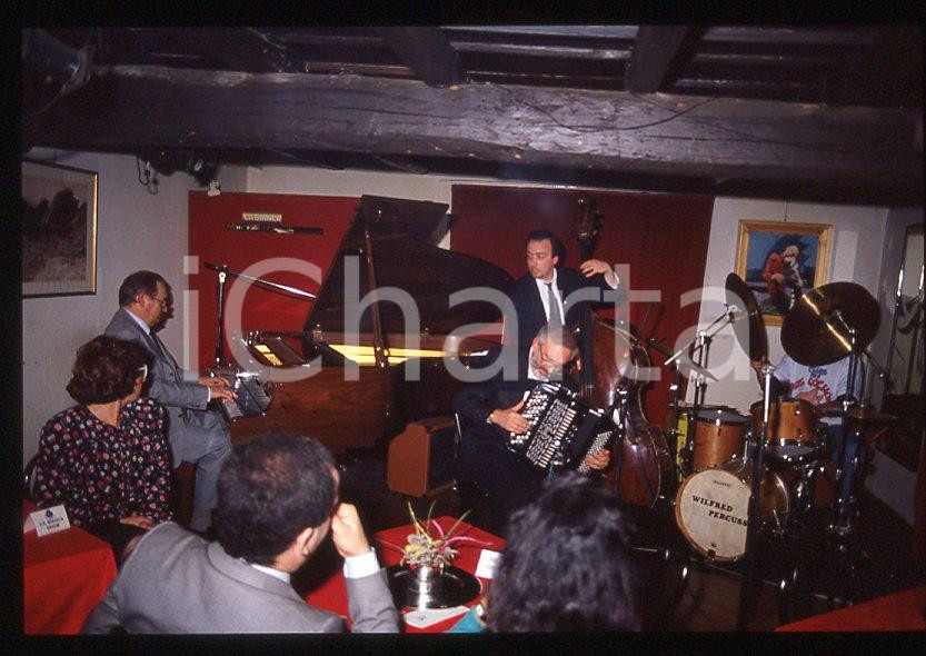 JAZZ Romano MUSSOLINI in concerto 1990 ca - 35mm vintage slide Diapositiva originale, in formato 35 mm.Per i diritti rivolgersi a ICharta.E' severamente vietata la riproduzione. Tutti i diritti sono riservati.ICharta mette in vendita, sul negozio eBay e in esclusiva sul sito "icharta" il proprio archivio composto da numerose diapositive e negativi fotografici d'epoca, tutti originali e autentici, che attraversano la storia del costume tra la fine degli anni Sessanta e Novanta.Si tratta di uno sguardo inedito sull'attualità , la politica, la vita quotidiana, il gossip e la cultura, che fotografa il cambiamento della nazione in quest'ultimo scorcio del XX secolo.Un'occasione unica per il mercato del collezionismo, che vede finalmente disponibile un archivio eccezionale per vastità , tematiche e condizioni, in un settore (il negativo fotografico e la diapositiva) di assoluta novità e dalle interessanti prospettive di investimento. GOOD/buono   originale e autentica 1