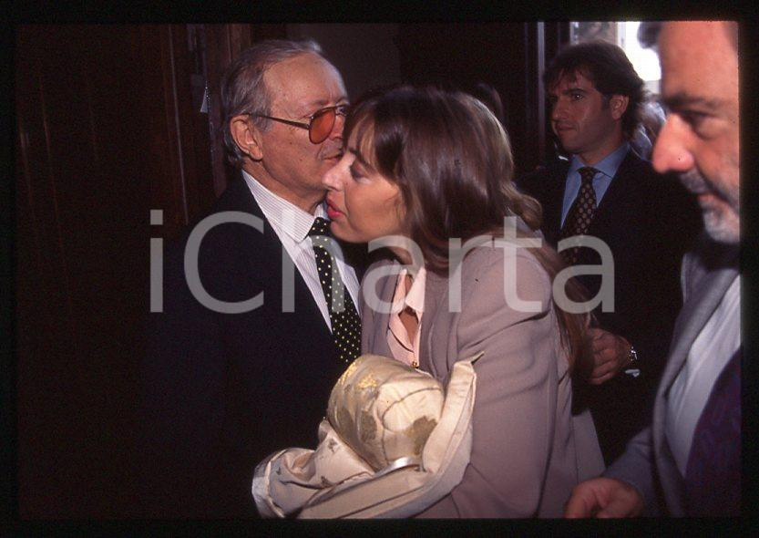 Elisabetta e Romano MUSSOLINI Battesimo Marco SANTOBONI 1998 35mm vintage slide Diapositiva originale, in formato 35 mm.Per i diritti rivolgersi a ICharta.E' severamente vietata la riproduzione. Tutti i diritti sono riservati.ICharta mette in vendita, sul negozio eBay e in esclusiva sul sito "icharta" il proprio archivio composto da numerose diapositive e negativi fotografici d'epoca, tutti originali e autentici, che attraversano la storia del costume tra la fine degli anni Sessanta e Novanta.Si tratta di uno sguardo inedito sull'attualità , la politica, la vita quotidiana, il gossip e la cultura, che fotografa il cambiamento della nazione in quest'ultimo scorcio del XX secolo.Un'occasione unica per il mercato del collezionismo, che vede finalmente disponibile un archivio eccezionale per vastità , tematiche e condizioni, in un settore (il negativo fotografico e la diapositiva) di assoluta novità e dalle interessanti prospettive di investimento. GOOD/buono   originale e autentica 1