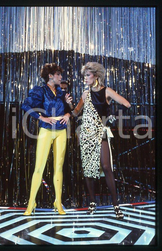 Amanda LEAR Nadia CASSINI CANALE 5 Premiatissima 1983 - 35mm vintage slide (3) Diapositiva originale, in formato 35 mm.Per i diritti rivolgersi a ICharta.E' severamente vietata la riproduzione. Tutti i diritti sono riservati.ICharta mette in vendita, sul negozio eBay e in esclusiva sul sito "icharta" il proprio archivio composto da numerose diapositive e negativi fotografici d'epoca, tutti originali e autentici, che attraversano la storia del costume tra la fine degli anni Sessanta e Novanta.Si tratta di uno sguardo inedito sull'attualità , la politica, la vita quotidiana, il gossip e la cultura, che fotografa il cambiamento della nazione in quest'ultimo scorcio del XX secolo.Un'occasione unica per il mercato del collezionismo, che vede finalmente disponibile un archivio eccezionale per vastità , tematiche e condizioni, in un settore (il negativo fotografico e la diapositiva) di assoluta novità e dalle interessanti prospettive di investimento. GOOD/buono   originale e autentica 1