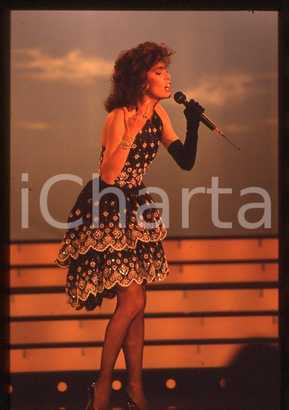 Nadia CASSINI canta a CAMPIONE D'ITALIA 1988 - 35mm vintage slide (1) Diapositiva originale, in formato 35 mm.Per i diritti rivolgersi a ICharta.E' severamente vietata la riproduzione. Tutti i diritti sono riservati.ICharta mette in vendita, sul negozio eBay e in esclusiva sul sito "icharta" il proprio archivio composto da numerose diapositive e negativi fotografici d'epoca, tutti originali e autentici, che attraversano la storia del costume tra la fine degli anni Sessanta e Novanta.Si tratta di uno sguardo inedito sull'attualità , la politica, la vita quotidiana, il gossip e la cultura, che fotografa il cambiamento della nazione in quest'ultimo scorcio del XX secolo.Un'occasione unica per il mercato del collezionismo, che vede finalmente disponibile un archivio eccezionale per vastità , tematiche e condizioni, in un settore (il negativo fotografico e la diapositiva) di assoluta novità e dalle interessanti prospettive di investimento. GOOD/buono   originale e autentica 1