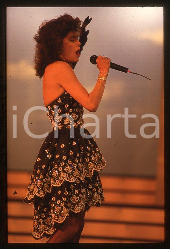 Nadia CASSINI canta a CAMPIONE D'ITALIA 1988 - 35mm vintage slide (2) Diapositiva originale, in formato 35 mm.Per i diritti rivolgersi a ICharta.E' severamente vietata la riproduzione. Tutti i diritti sono riservati.ICharta mette in vendita, sul negozio eBay e in esclusiva sul sito "icharta" il proprio archivio composto da numerose diapositive e negativi fotografici d'epoca, tutti originali e autentici, che attraversano la storia del costume tra la fine degli anni Sessanta e Novanta.Si tratta di uno sguardo inedito sull'attualità , la politica, la vita quotidiana, il gossip e la cultura, che fotografa il cambiamento della nazione in quest'ultimo scorcio del XX secolo.Un'occasione unica per il mercato del collezionismo, che vede finalmente disponibile un archivio eccezionale per vastità , tematiche e condizioni, in un settore (il negativo fotografico e la diapositiva) di assoluta novità e dalle interessanti prospettive di investimento. GOOD/buono   originale e autentica 1