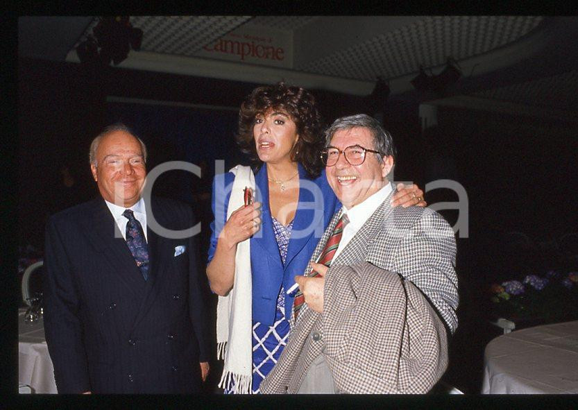 Salvatore FIUME Nadia CASSINI - CAMPIONE D'ITALIA 1985 ca - 35mm vintage slide 1 Diapositiva originale, in formato 35 mm.Per i diritti rivolgersi a ICharta.E' severamente vietata la riproduzione. Tutti i diritti sono riservati.ICharta mette in vendita, sul negozio eBay e in esclusiva sul sito "icharta" il proprio archivio composto da numerose diapositive e negativi fotografici d'epoca, tutti originali e autentici, che attraversano la storia del costume tra la fine degli anni Sessanta e Novanta.Si tratta di uno sguardo inedito sull'attualità , la politica, la vita quotidiana, il gossip e la cultura, che fotografa il cambiamento della nazione in quest'ultimo scorcio del XX secolo.Un'occasione unica per il mercato del collezionismo, che vede finalmente disponibile un archivio eccezionale per vastità , tematiche e condizioni, in un settore (il negativo fotografico e la diapositiva) di assoluta novità e dalle interessanti prospettive di investimento. GOOD/buono   originale e autentica 1