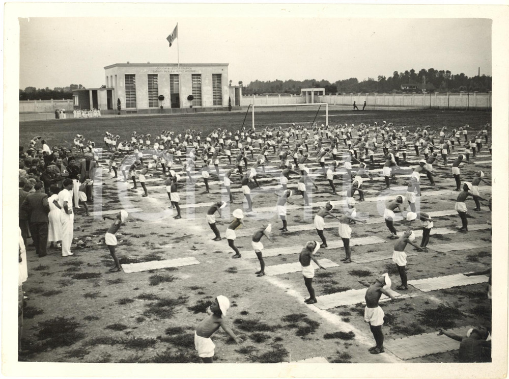 1936 PARABIAGO Colonia Elioterapica - Saggio ginnico dei bambini *Foto 24x18  Fotografia originale d'epoca, con didascalia dattiloscritta al verso.Si tratta dell'attuale stadio "Libero Ferrario", all'epoca colonia elioterapica "Caduti per la rivoluzione". FAIR/discreto graffi e sovraimpressione al lato destro Formato: 24x18 cm originale e autentica 1