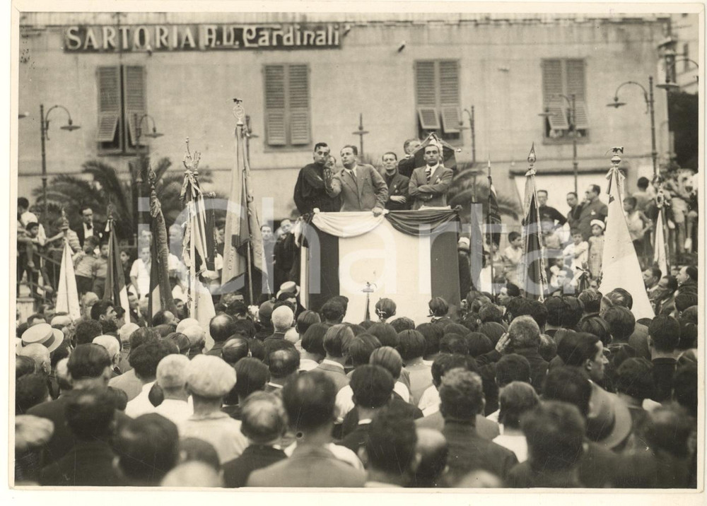 1933 PNF GENOVA SESTRI PONENTE Discorso on. Ugo CLAVENZANI *Foto 17x12 cm  Fotografia originale d'epoca, con timbro datario e didascalia manoscritta al verso: "Il gruppo fascista di Genova Sestri consegna il labaro alla delegazione dei Sindacati dell'Industria. Parla l'on. Clavenzani. A sinistra il dott. Angelo Tarchi, segretario dei Sindacati, e il Segretario Federale dott. Giorgio Molfino".Visibile l'insegna della sartoria A. V. Cardinali. FAIR/discreto lievi ondulature; tracce di colla al verso Formato: 17x12 cm originale e autentica 1